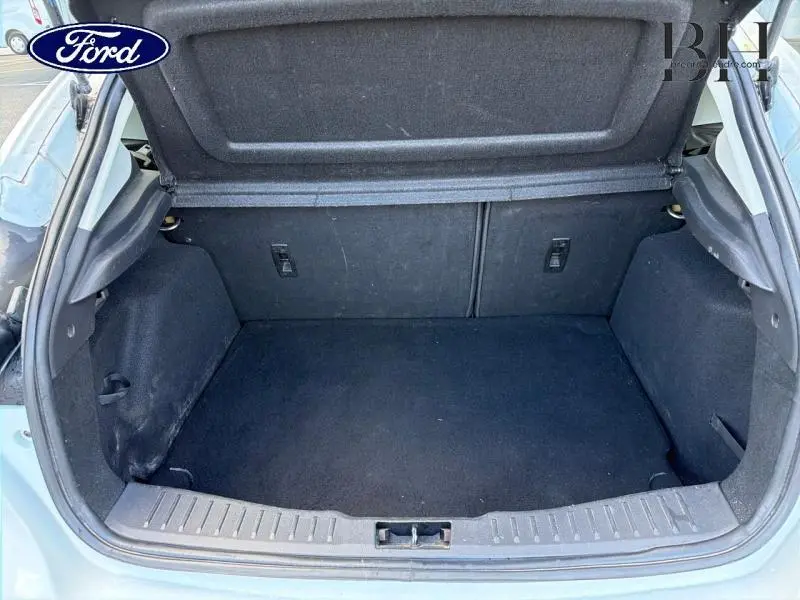 Coffre ouvert vu de l'arrière d'une Ford Focus blanc glacier, intérieur noir et espace de rangement vide.