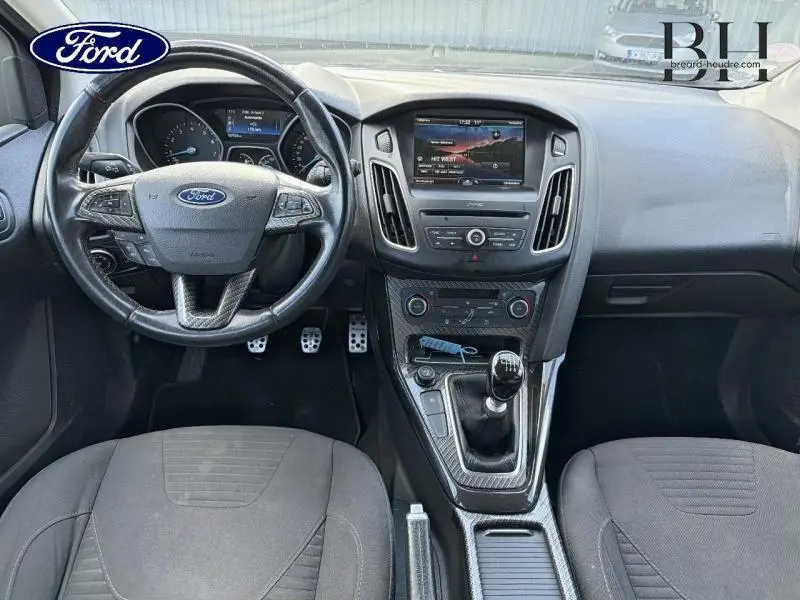 Vue intérieure avant de la Ford Focus 1.0 EcoBoost 2016, volant cuir multifonction et console centrale avec écran tactile.