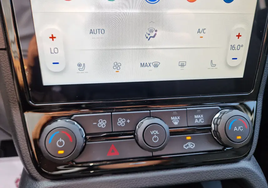 Gros plan sur la console centrale du Ford Ranger Super Cabine gris Iconic, montrant les commandes de climatisation et volume.