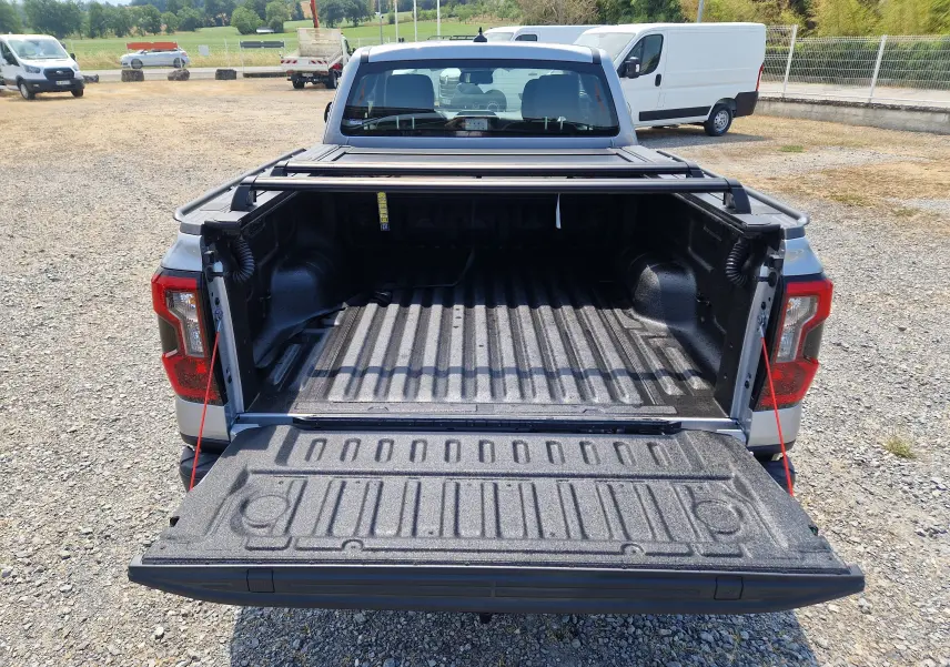 Vue arrière du Ford Ranger Super Cabine gris Iconic avec le plateau ouvert et son rideau rigide coulissant visible.