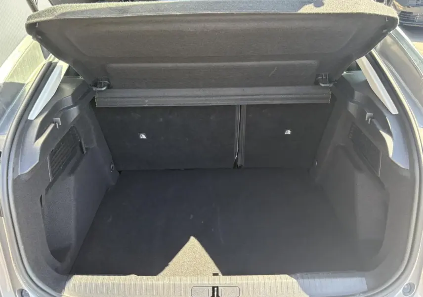 Coffre ouvert vu de l'arrière d'une Citroën C4 Hybrid 145 gris Mercury, espace de chargement vide et propre.