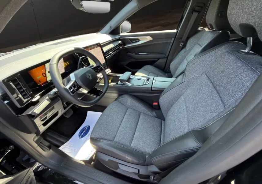 Intérieur avant droit de la Renault Rafale 2025 noir, sièges tissu gris, tableau de bord avec écran tactile vertical.