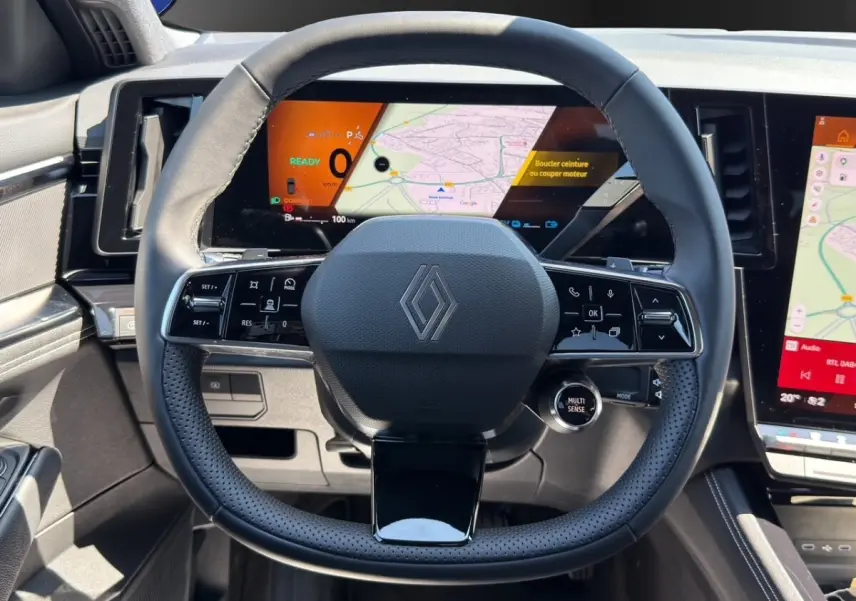 Vue centrée sur le volant noir perforé de la Renault Rafale 2025 avec tableau de bord numérique et écran tactile visible.