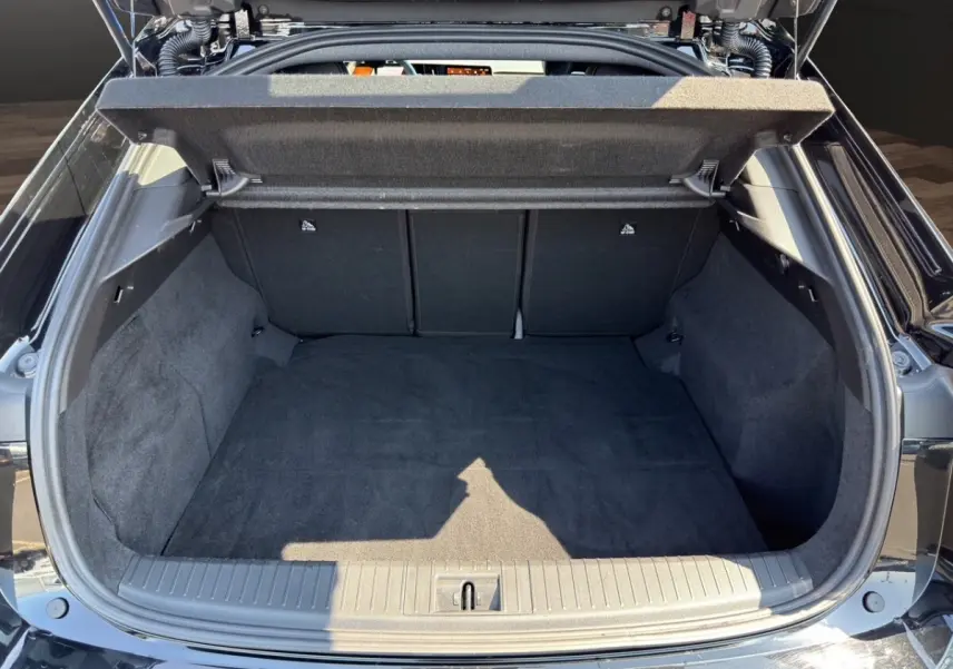 Coffre ouvert vu de l'arrière d'une Renault Rafale noire 2025, montrant l'espace de chargement vide et la moquette noire.