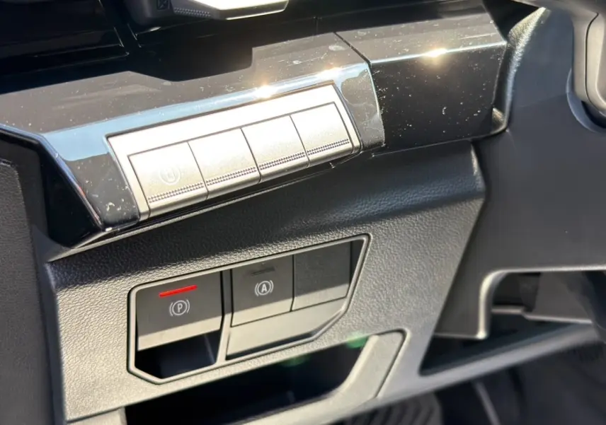 Détail intérieur côté conducteur du Renault Rafale 2025 noir, montrant les commandes électroniques du frein à main et du démarrage.