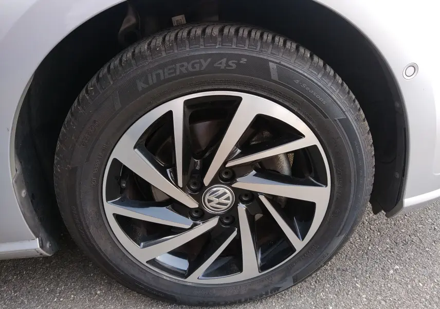 Gros plan sur la roue avant droite d'une Volkswagen Golf gris reflet d'argent avec jante alliage bicolore.