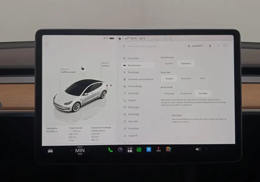 Écran tactile central montrant la configuration d'une Tesla Model 3 blanche vue en 3/4 avant.