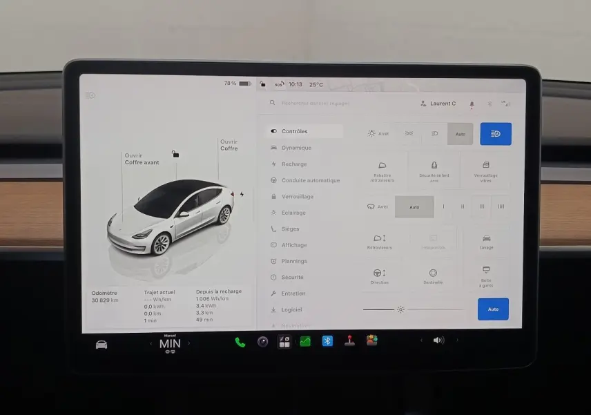 Écran tactile central affichant la Tesla Model 3 blanche en vue 3/4 avant avec commandes et réglages du véhicule.