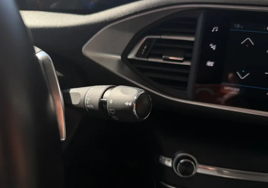 Gros plan sur la commande d'essuie-glace côté gauche du tableau de bord noir de la Peugeot 308 SW 2021.