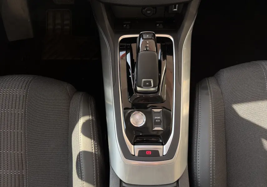 Vue plongeante sur la console centrale de la Peugeot 308 SW 2021, avec levier de boîte auto et bouton start/stop.
