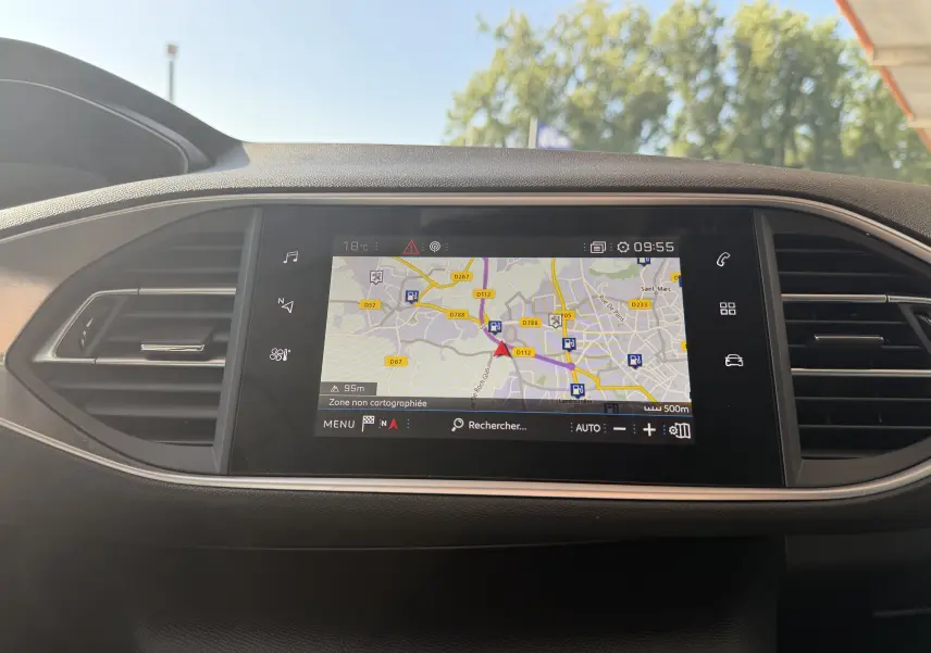 Écran tactile central du tableau de bord de la Peugeot 308 SW 2021, affichant la navigation GPS en mode jour.