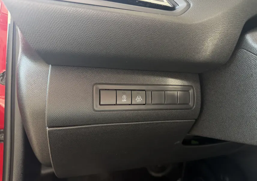 Gros plan sur les boutons de commande du tableau de bord côté gauche d’une Peugeot 308 SW rouge rubis de 2021.