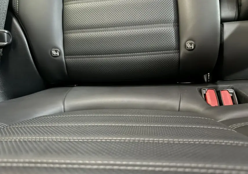 Gros plan sur la banquette arrière en cuir noir perforé avec ceintures rouges de l'Alfa Romeo Tonale hybride 2023.