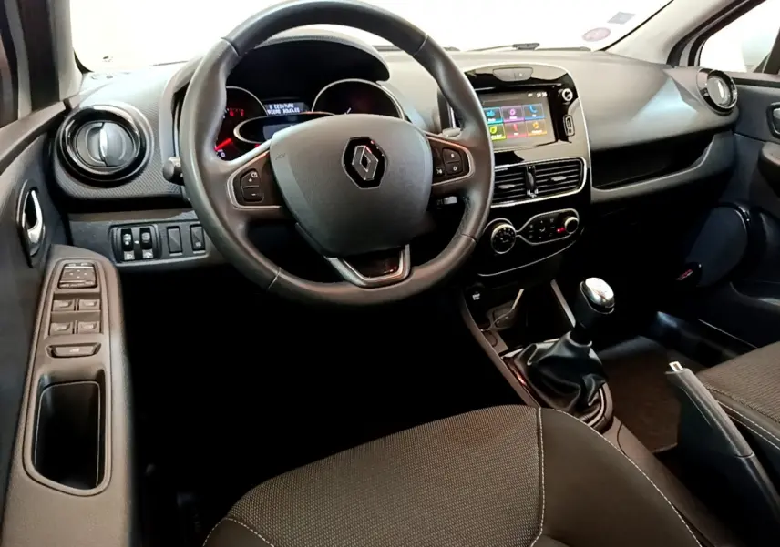 Vue intérieure avant droite de la Renault Clio Business TCe 90 2019, tableau de bord noir avec écran tactile et volant cuir.