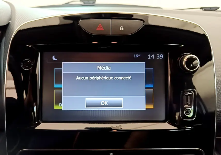 Écran tactile central noir affichant un message média sans périphérique connecté dans une Renault Clio Business blanche.