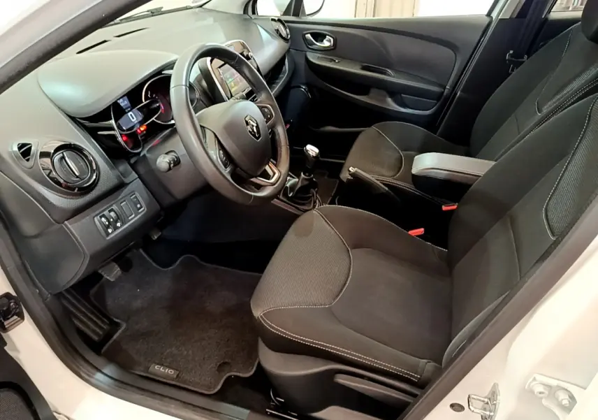 Intérieur côté conducteur de la Renault Clio Business blanche 2019, volant cuir et tableau de bord avec écran tactile.