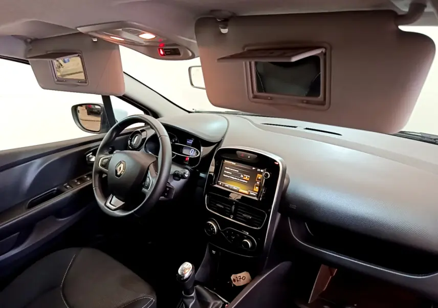 Intérieur de Renault Clio Business TCe 90 2019, vue côté conducteur, volant cuir et écran tactile central allumé.
