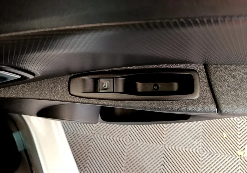 Détail de la commande de lève-vitre côté conducteur dans l'habitacle d'une Renault Clio Business blanc 2019.
