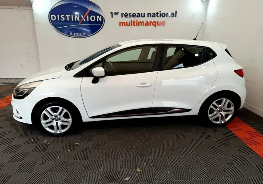 Profil côté gauche d'une Renault Clio Business TCe 90 blanche, avec jantes alliage et poignées de porte assorties.