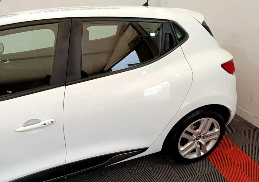 Profil côté gauche d'une Renault Clio Business TCe 90 blanche, mettant en valeur la porte arrière et la jante alliage.