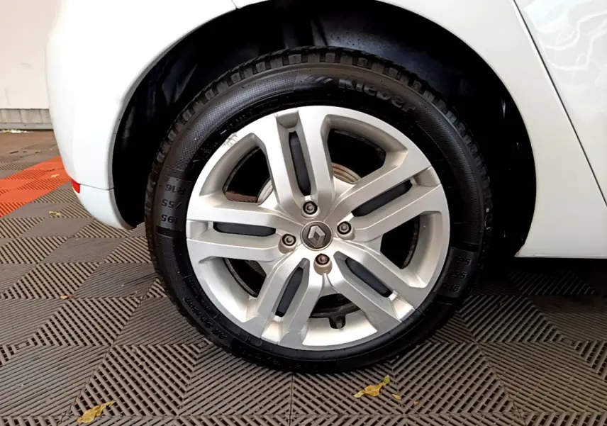 Vue rapprochée de l'aile arrière droite blanche d'une Renault Clio Business TCe 90 de 2019, sur sol carrelé.