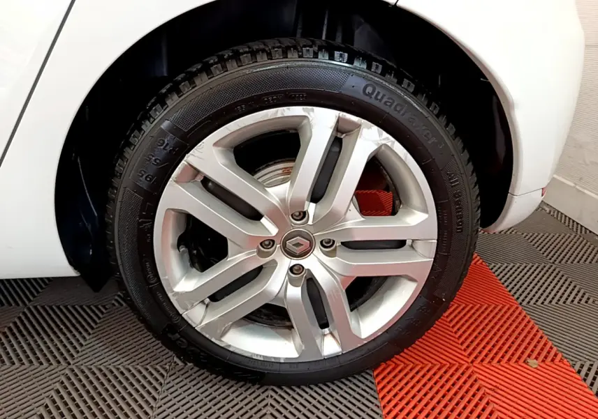 Gros plan sur la roue avant droite blanche d'une Renault Clio Business TCe 90 avec jante alliage argentée.