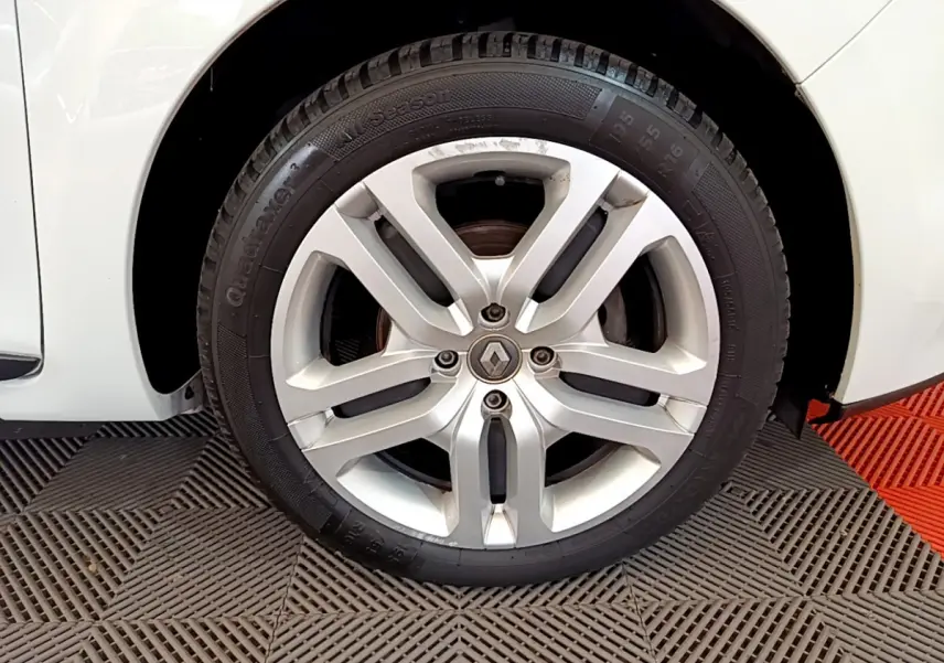 Gros plan sur la roue avant droite blanche d'une Renault Clio Business TCe 90 avec jante alliage argentée.