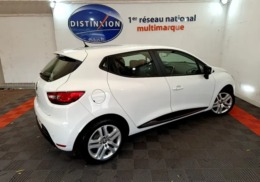 Renault Clio Business TCe 90 blanc vue 3/4 arrière droit en intérieur avec jantes alliage et feux arrière LED.