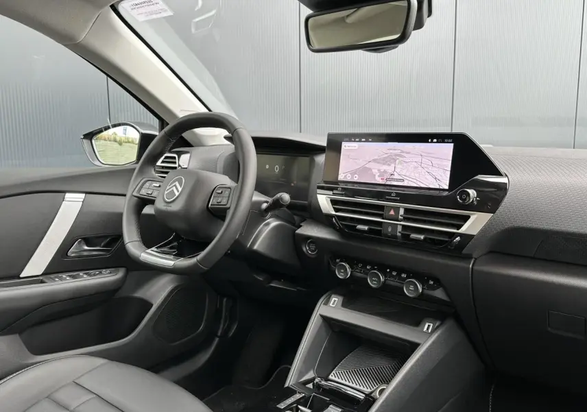 Intérieur avant droit de la Citroën C4 Manhattan Green 2025, avec écran tactile GPS et volant cuir noir.