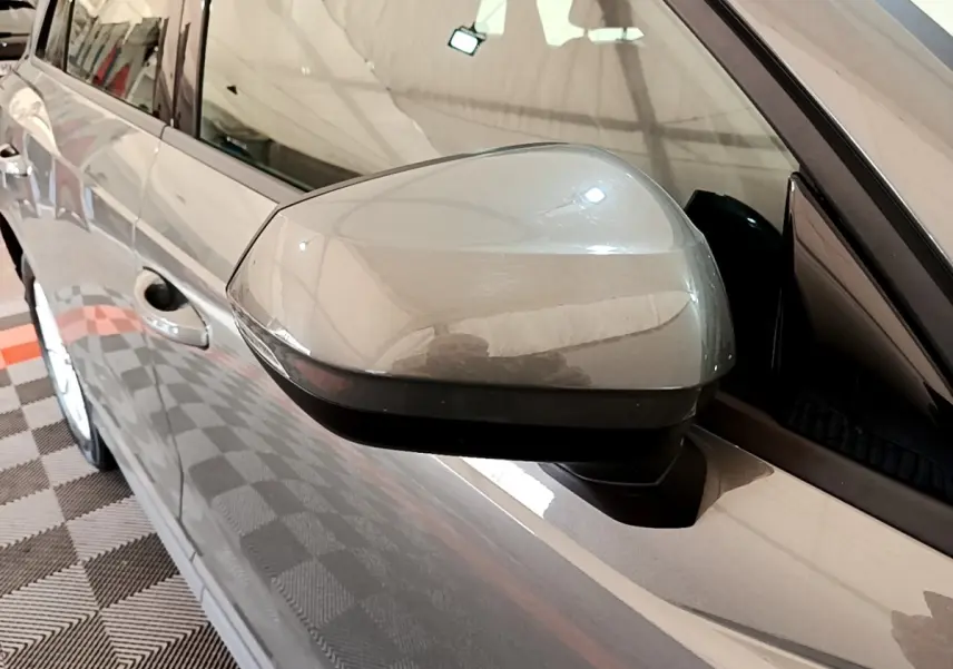 Rétroviseur côté gauche gris foncé de l'Audi Q3 35 TFSI 2021, vue rapprochée sur la portière et la vitre.