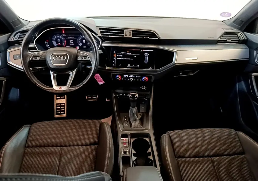 Vue intérieure avant de l'Audi Q3 35 TFSI S Line 2021, avec tableau de bord numérique et volant cuir multifonctions.