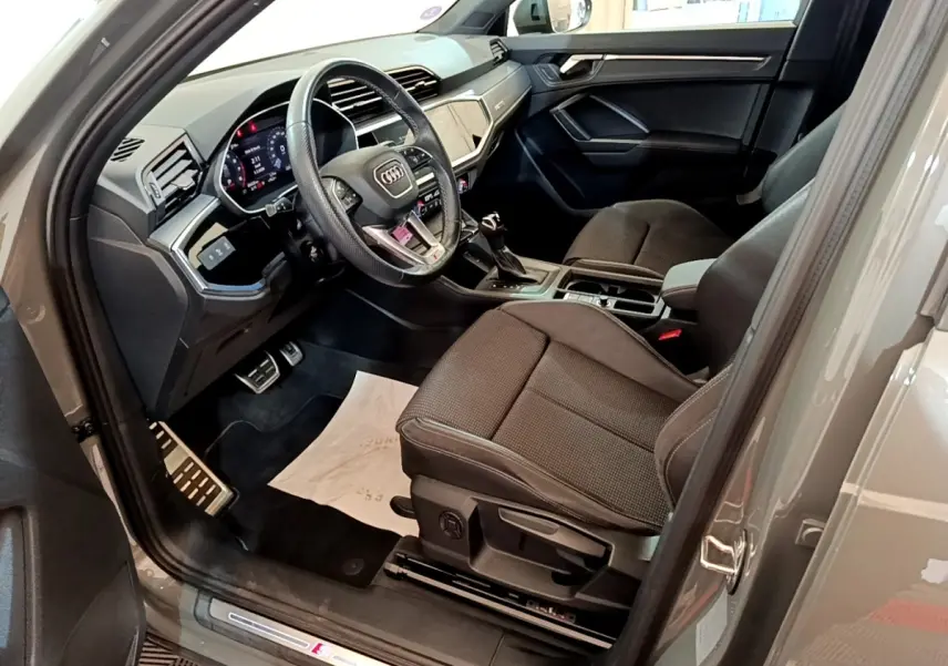 Intérieur Audi Q3 35 TFSI S line 2021 gris foncé, vue côté conducteur avec volant cuir multifonctions et tableau de bord digital.