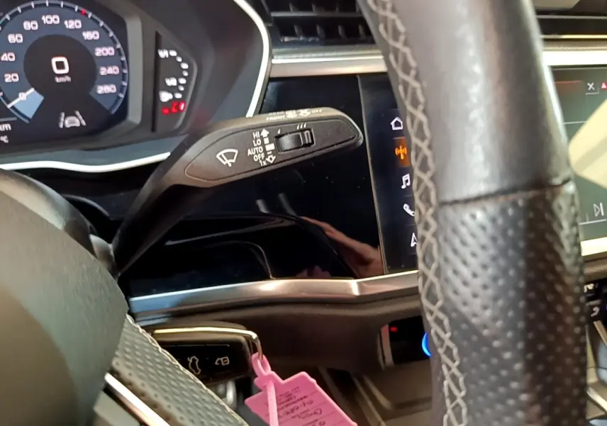 Vue rapprochée du volant cuir multifonctions et du tableau de bord digital de l’Audi Q3 gris foncé 2021.