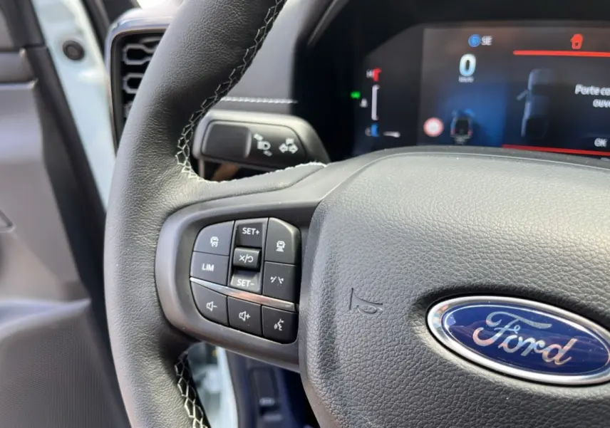 Gros plan sur le volant cuir multifonctions du Ford Ranger gris zen avec commandes intégrées et tableau de bord numérique.
