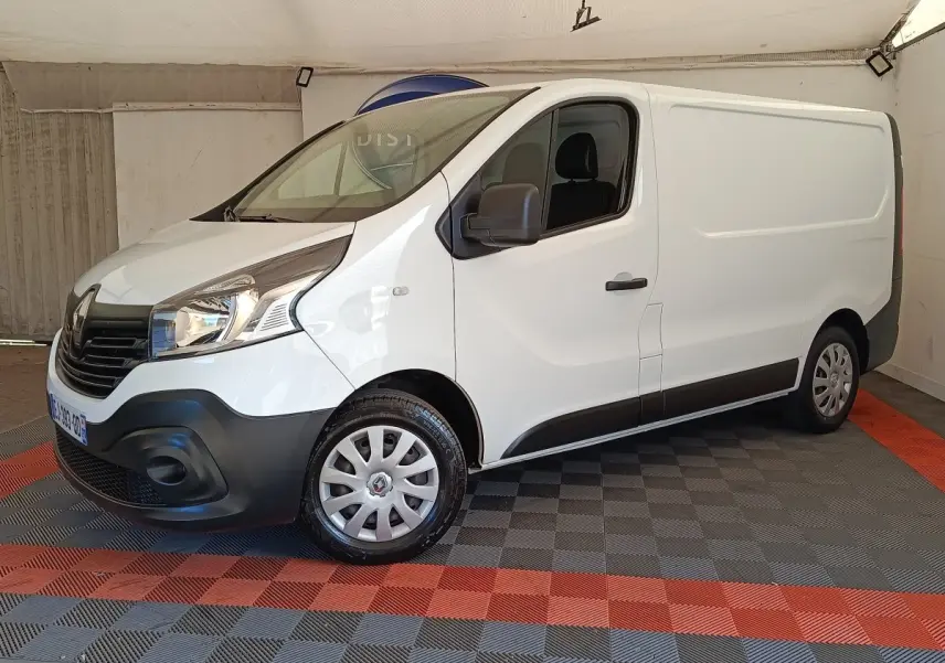 Fourgon Renault Trafic blanc vu en 3/4 avant droit, avec pare-chocs noir et jantes acier à enjoliveurs.