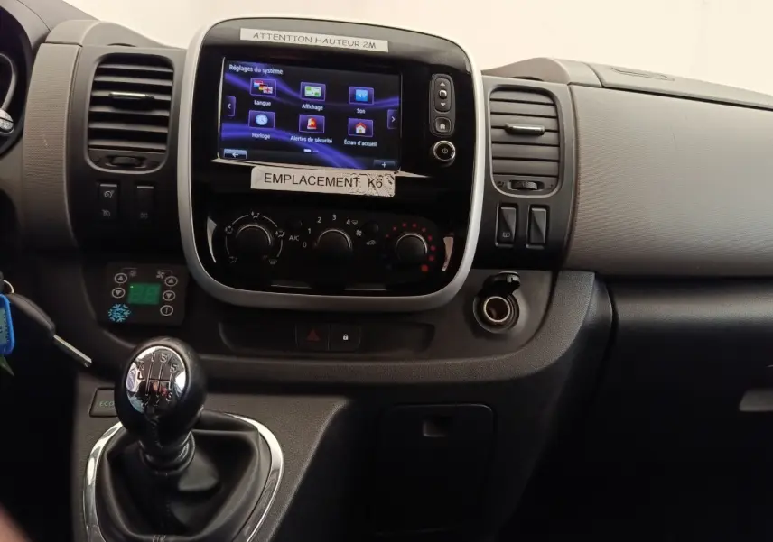Vue rapprochée du tableau de bord noir du Renault Trafic Fourgon 2017 avec écran tactile et levier de vitesse manuel.