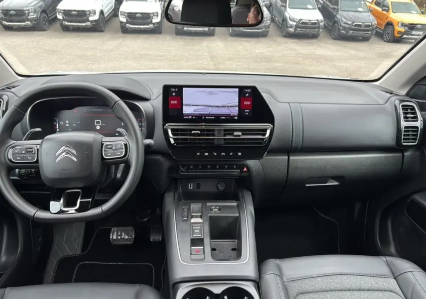 Vue intérieure avant du Citroën C5 Aircross Hybrid blanc, tableau de bord moderne avec écran tactile central.