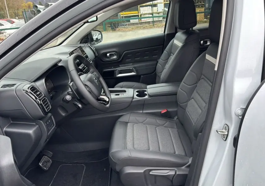 Vue intérieure côté conducteur du Citroën C5 Aircross Hybrid 145 e-DSC6 Max blanc Okenite, sièges en cuir et tissu gris.