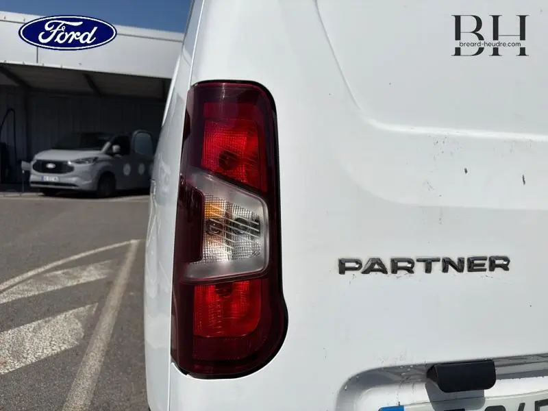 Gros plan sur le feu arrière gauche blanc du Peugeot Partner 2019 avec logo et inscription "PARTNER" visible sur la porte arrière.
