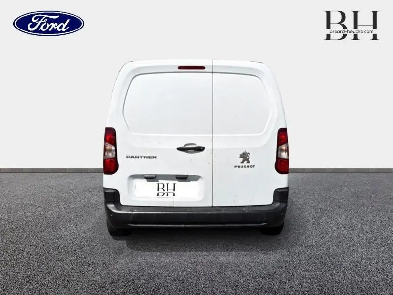 Vue arrière d'un Peugeot Partner blanc avec portes battantes et logo visible sur fond neutre.