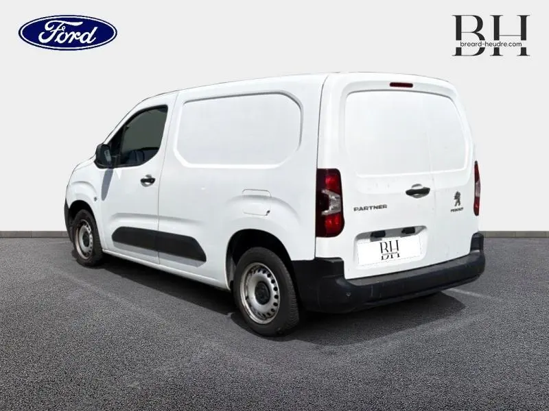 Vue 3/4 arrière droite d'un Peugeot Partner blanc Icy, fourgon utilitaire avec portes battantes arrière et porte latérale droite.