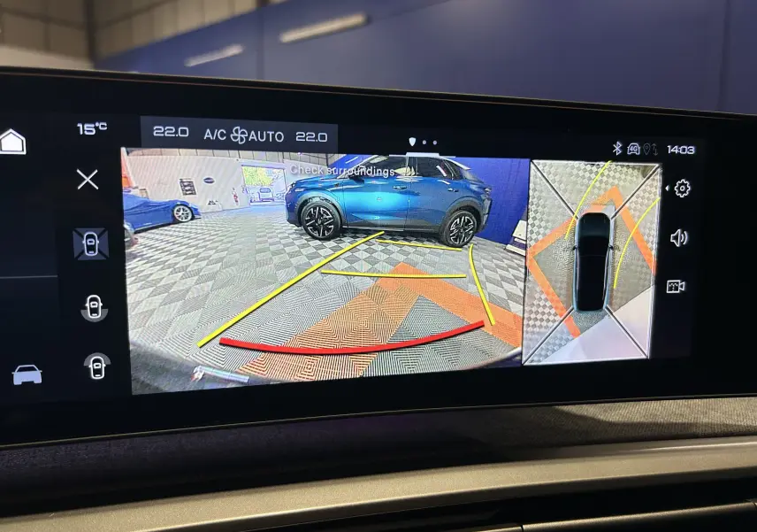 Affichage caméra 360° avec vue arrière et latérale d’un Peugeot 3008 blanc Okenite en stationnement intérieur.
