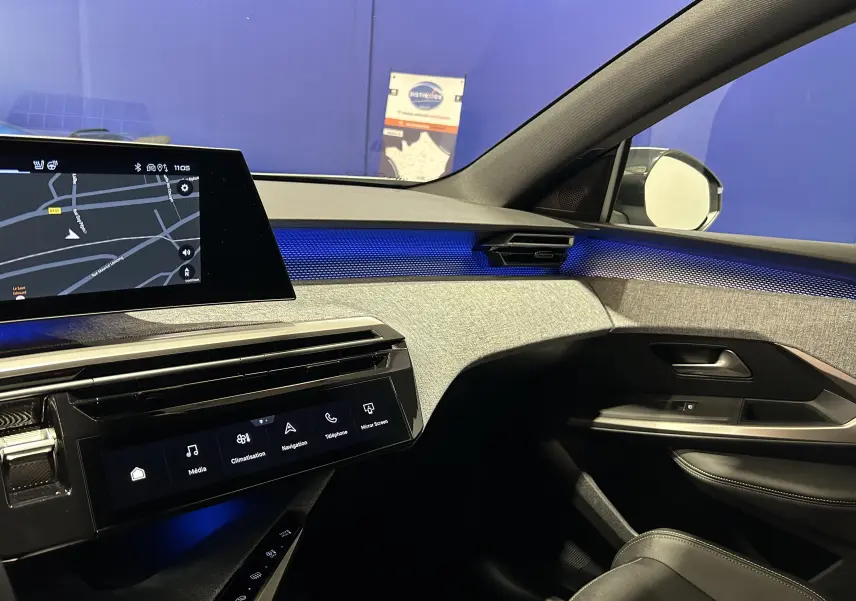Vue intérieure côté passager du Peugeot 3008 III Hybrid avec éclairage d'ambiance bleu et écran tactile de navigation.