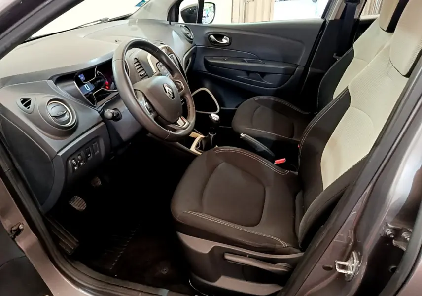 Vue intérieure côté conducteur du Renault Captur Business gris foncé de 2018, montrant le volant cuir et la console centrale.