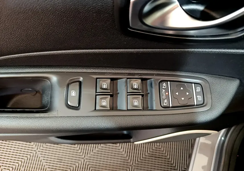 Vue rapprochée des commandes de lève-vitres et rétroviseurs sur la porte côté conducteur d'un Renault Captur gris foncé 2018.