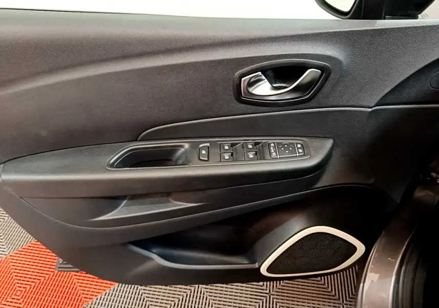 Vue rapprochée de la porte avant gauche gris foncé du Renault Captur avec commandes électriques et haut-parleur intégré.