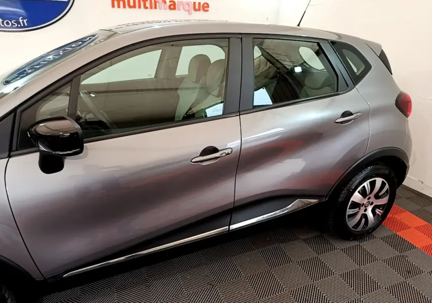 Profil côté gauche d'un Renault Captur gris foncé 2018 avec rétroviseurs noirs et jantes alliage visibles.
