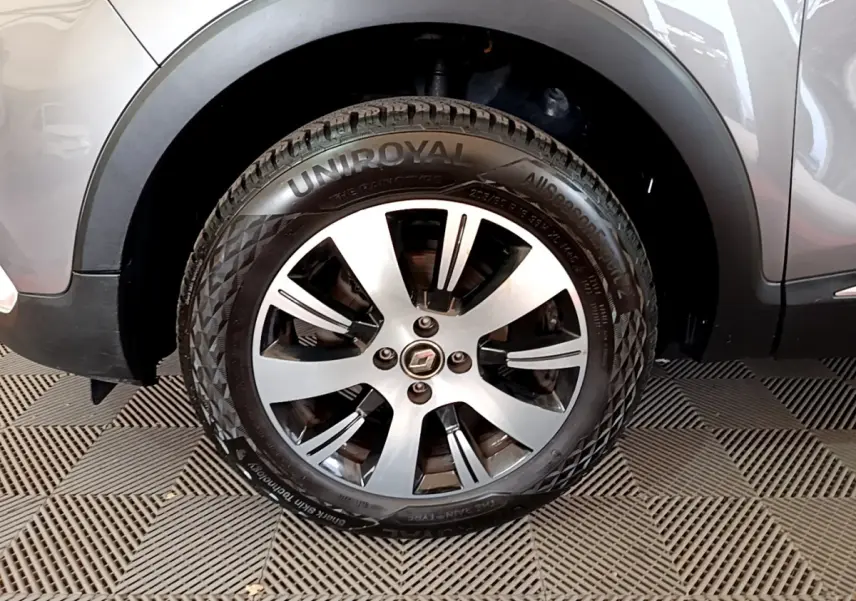 Gros plan sur la roue avant gauche du Renault Captur gris foncé, mettant en valeur la jante alliage et le pneu Uniroyal.