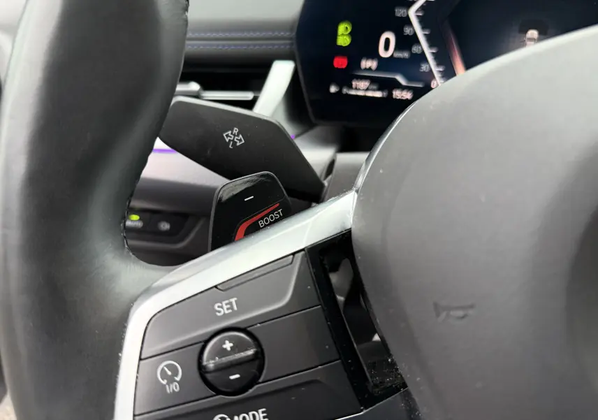 Gros plan sur le volant et les commandes de la BMW X1 18D M Sport 2025, avec affichage numérique du tableau de bord.