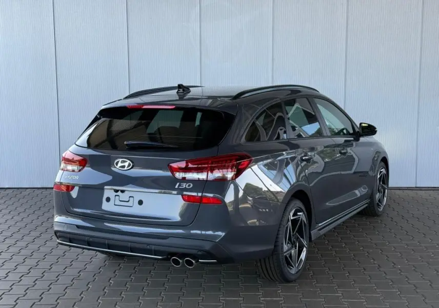 Vue 3/4 arrière droite d'une Hyundai i30 SW N-LINE gris foncé avec double sortie d'échappement et jantes sport.